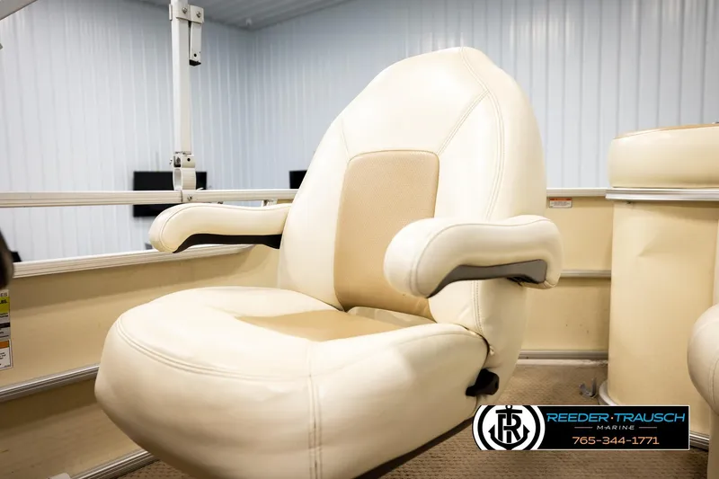 Slide: The Image of Captain's chair on 2004 AquaPatio 220 RE boat, featuring beige upholstery and armrests. - 37