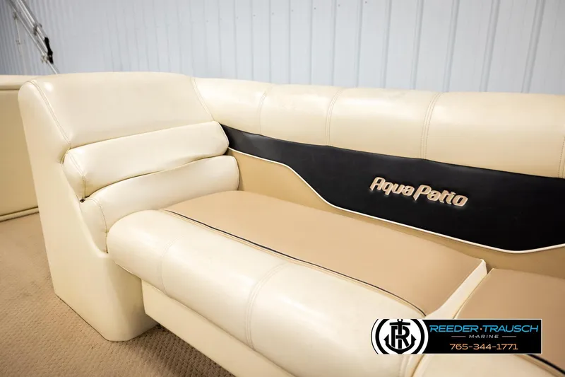Slide: The Image of 2004 AquaPatio 220 RE boat interior seating with beige and black upholstery. - 38