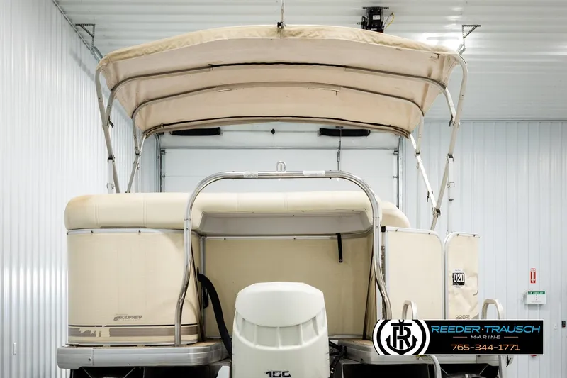 Slide: The Image of 2004 AquaPatio 220 RE pontoon boat in indoor storage, rear view. - 7