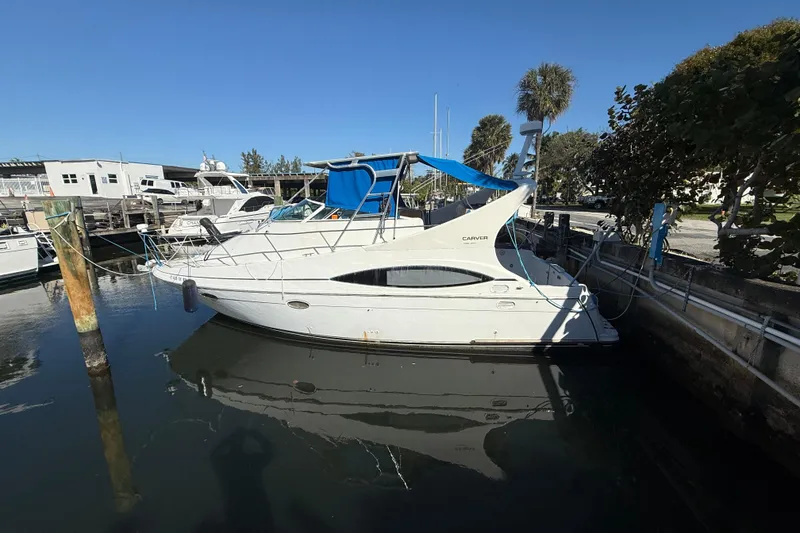 Slide: The Image of 2000 Carver 350 Mariner yacht docked in a marina under clear blue skies. - 1
