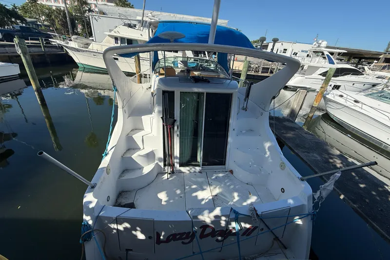 Slide: The Image of 2000 Carver 350 Mariner docked at marina, rear view with blue canopy. - 3