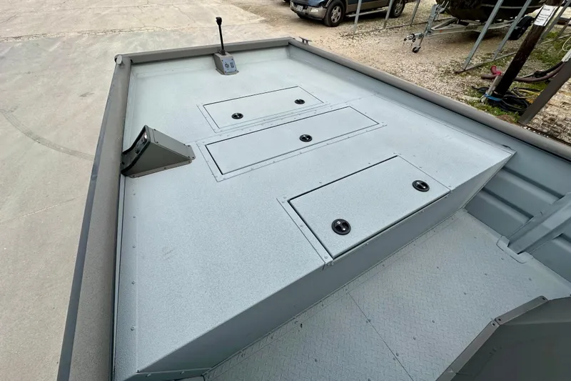 Slide: The Image of 2026 SeaArk 2472 CUB boat deck with storage compartments and control lever. - 10