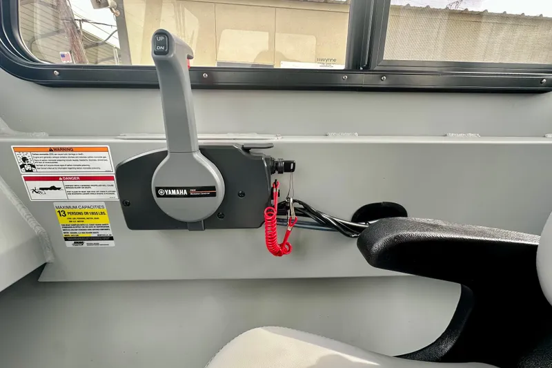Slide: The Image of Interior of 2026 SeaArk 2472 CUB boat with Yamaha control lever and safety warnings. - 24