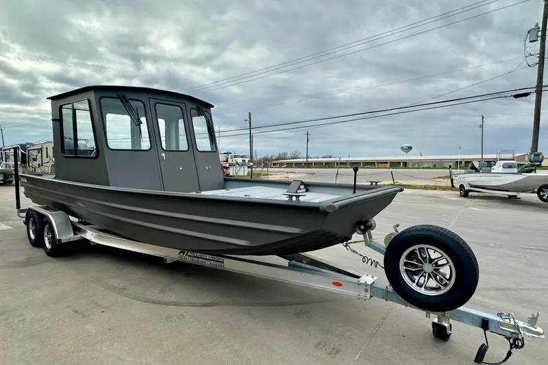 Slide: The Image of 2026 SeaArk 2472 CUB boat on trailer, parked outdoors under cloudy sky. - 3