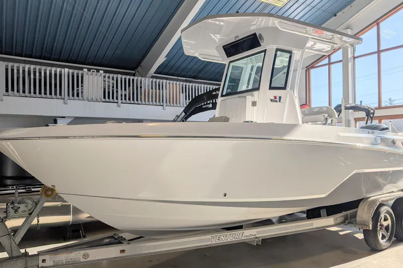 The Image of 2026 Wellcraft 223 Fisherman boat on trailer in showroom. - 0