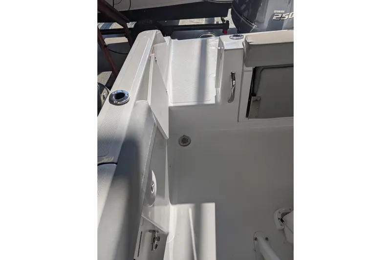 Slide: The Image of 2026 Wellcraft 223 Fisherman boat interior with seating and storage compartments. - 13