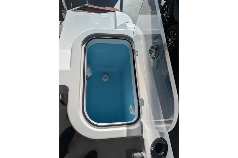 Slide: The Image of 2026 Wellcraft 223 Fisherman boat's open storage compartment with blue interior. - 15