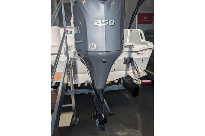 Slide: The Image of 2026 Wellcraft 223 Fisherman with Yamaha 250 outboard motor in a showroom. - 2