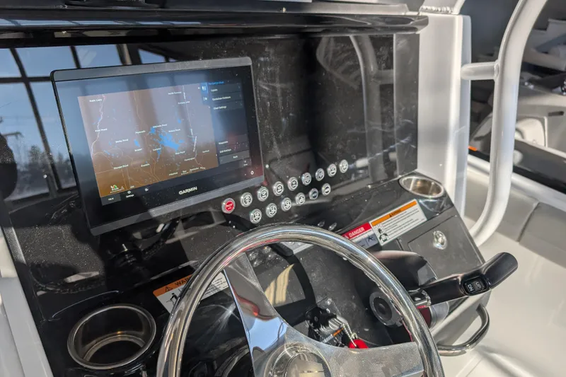Slide: The Image of 2026 Wellcraft 223 Fisherman dashboard with Garmin navigation display and steering wheel. - 3