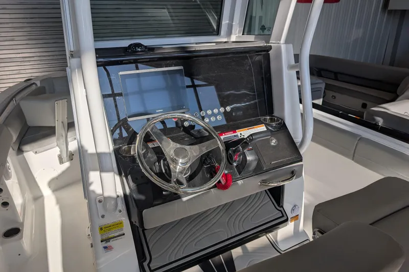 Slide: The Image of 2026 Wellcraft 223 Fisherman boat dashboard with steering wheel and navigation display. - 4