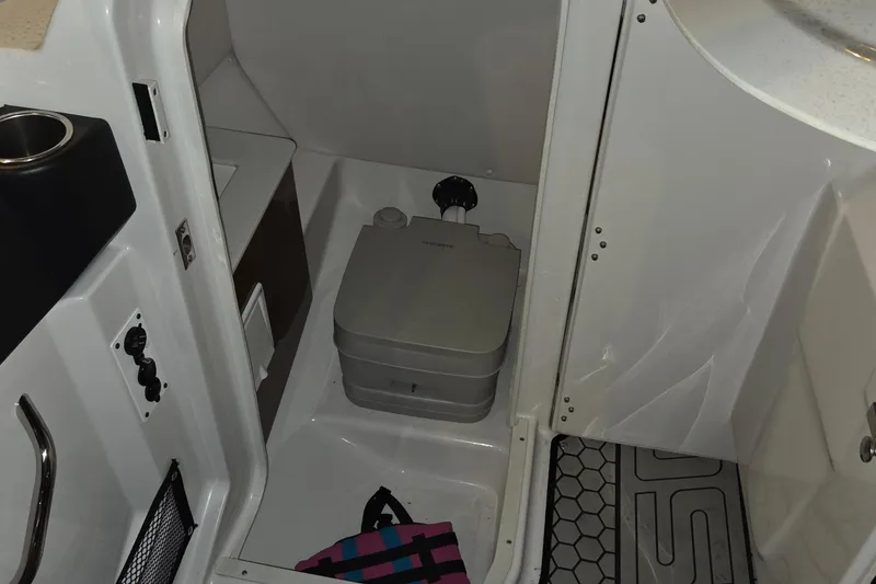Slide: The Image of 2018 Scarab 255 boat interior with portable toilet and storage area. - 11