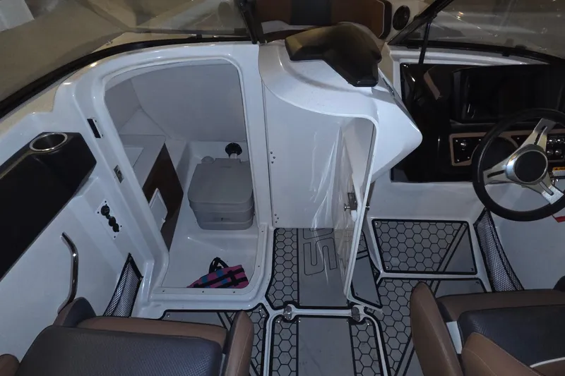 Slide: The Image of 2018 Scarab 255 boat interior with helm, seating, and storage area. - 12