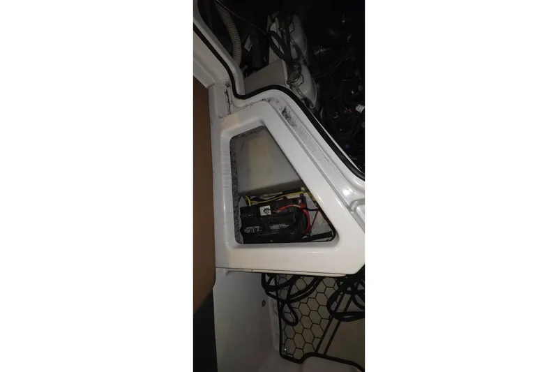 Slide: The Image of Battery compartment of a 2018 Scarab 255 boat, showing wiring and storage area. - 16