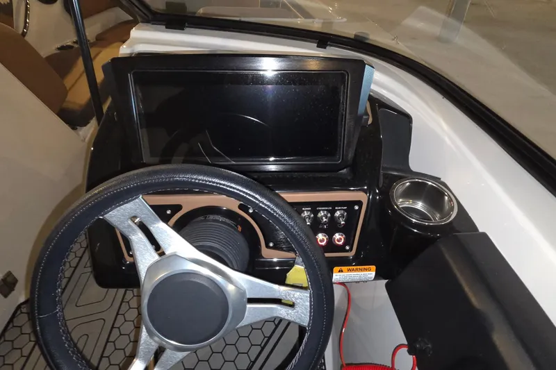 Slide: The Image of 2018 Scarab 255 boat dashboard with steering wheel and control panel. - 17