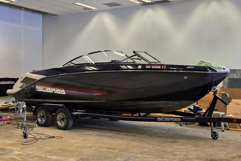 Slide: The Image of 2018 Scarab 255 boat on trailer in indoor setting. - 22