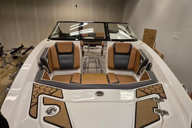 Slide: The Image of 2018 Scarab 255 boat interior with tan and black seating in a showroom. - 25