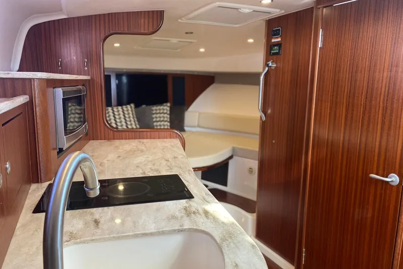 Slide: The Image of 2018 Pursuit OS 385 Offshore yacht interior with modern kitchen and cozy seating area. - 10