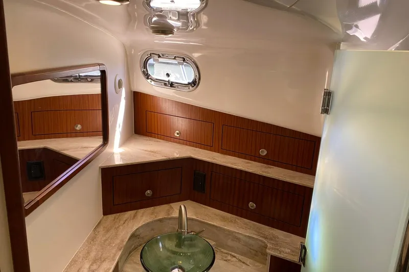 Slide: The Image of Luxurious bathroom interior of 2018 Pursuit OS 385 Offshore boat with wood accents and glass sink. - 13