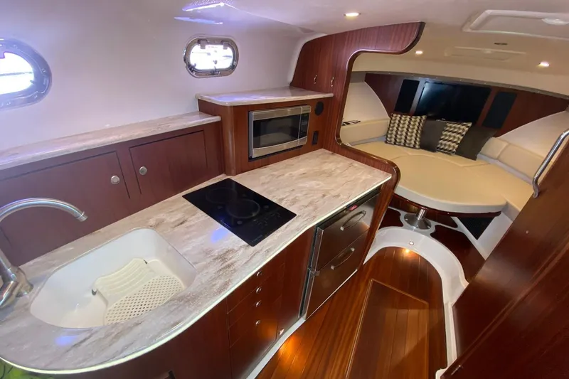 Slide: The Image of 2018 Pursuit OS 385 Offshore yacht interior with kitchen, seating area, and modern amenities. - 9