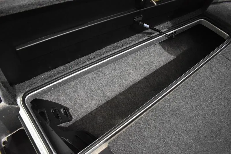Slide: The Image of 2026 Triton 18 TrX storage compartment with carpeted interior and secure latch. - 12