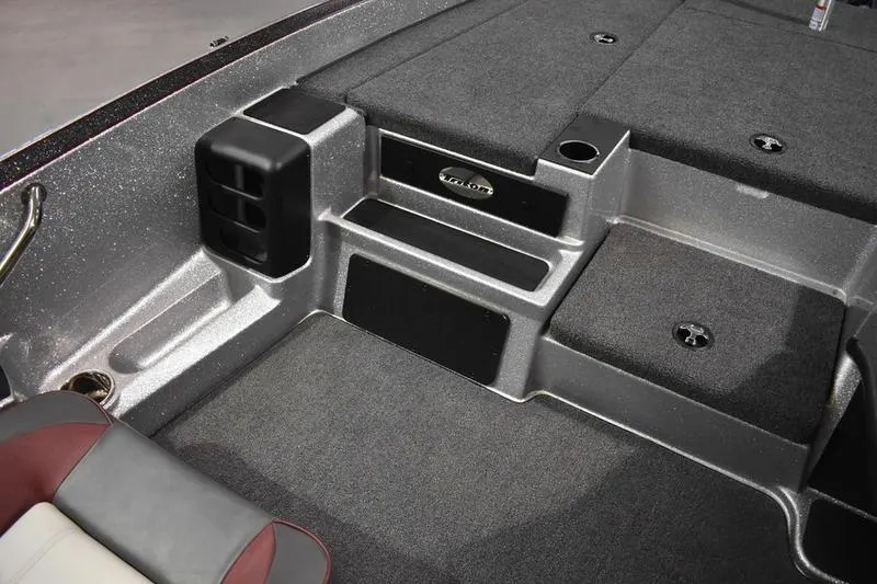 Slide: The Image of 2026 Triton 18 TrX boat interior with carpeted deck and seating area. - 16