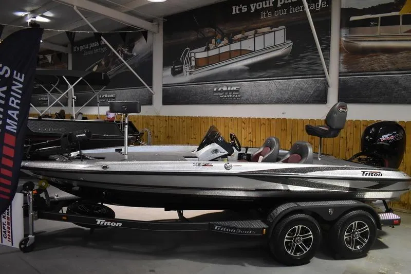 Slide: The Image of 2026 Triton 18 TrX boat displayed indoors on a trailer. - 4