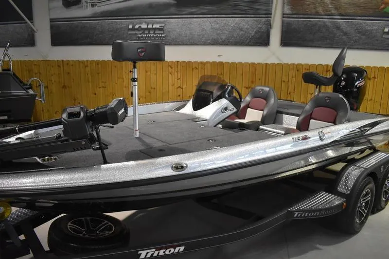 Slide: The Image of 2026 Triton 18 TrX bass boat in showroom, featuring sleek design and dual seating. - 5