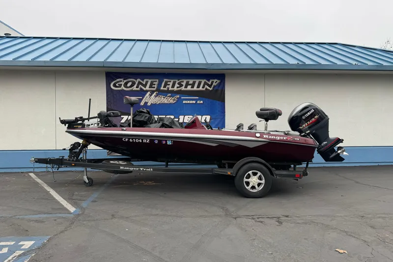 The Image of 2017 Ranger Z175 boat with Yamaha motor on trailer, parked outside a marine shop. - 0
