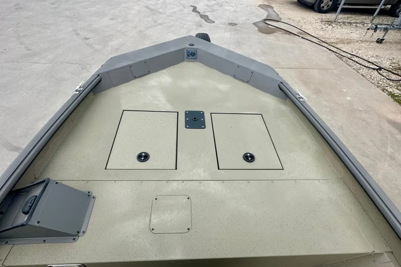 Slide: The Image of 2026 SeaArk Shadow 17 boat deck with storage compartments, shown on a concrete surface. - 11