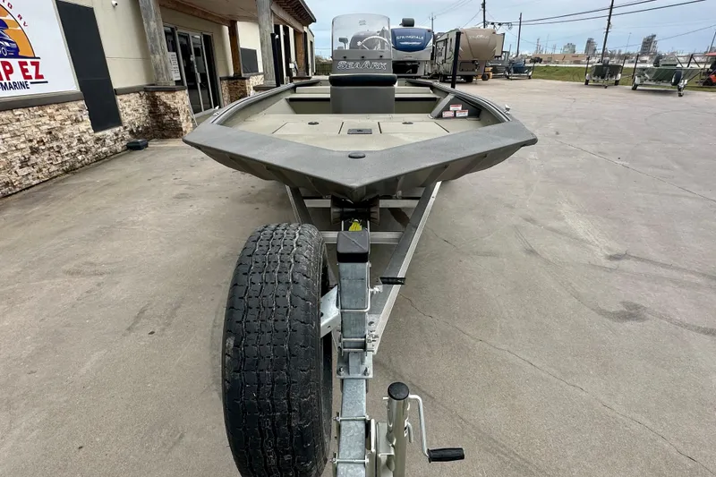 Slide: The Image of 2026 SeaArk Shadow 17 boat on trailer, parked outside a building. - 2