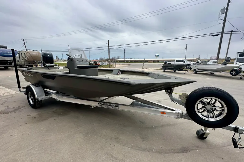Slide: The Image of 2026 SeaArk Shadow 17 boat on trailer, parked outdoors under cloudy sky. - 3