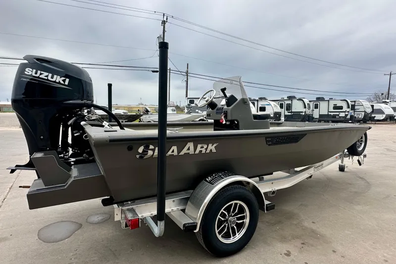 Slide: The Image of 2026 SeaArk Shadow 17 boat with Suzuki engine on trailer, parked outdoors. - 4