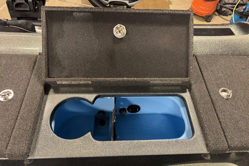 Slide: The Image of Open storage compartment in 2018 Nitro ZV21 boat, featuring a blue interior. - 10