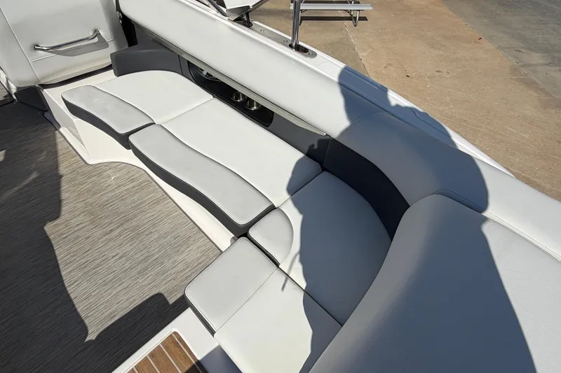 Slide: The Image of 2017 Regal 2700 ES Bowrider interior seating with gray upholstery and cup holders. - 13