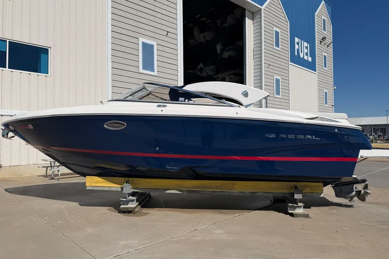 Slide: The Image of 2017 Regal 2700 ES Bowrider boat in blue, docked near a fuel station. - 5