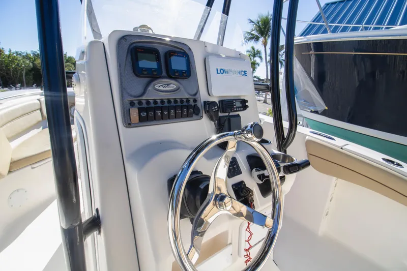 Slide: The Image of 2015 Tidewater 230 LXF boat console with steering wheel and navigation controls. - 7