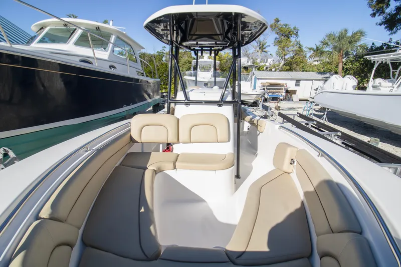 Slide: The Image of 2015 Tidewater 230 LXF boat interior with beige seating, docked among other boats. - 9