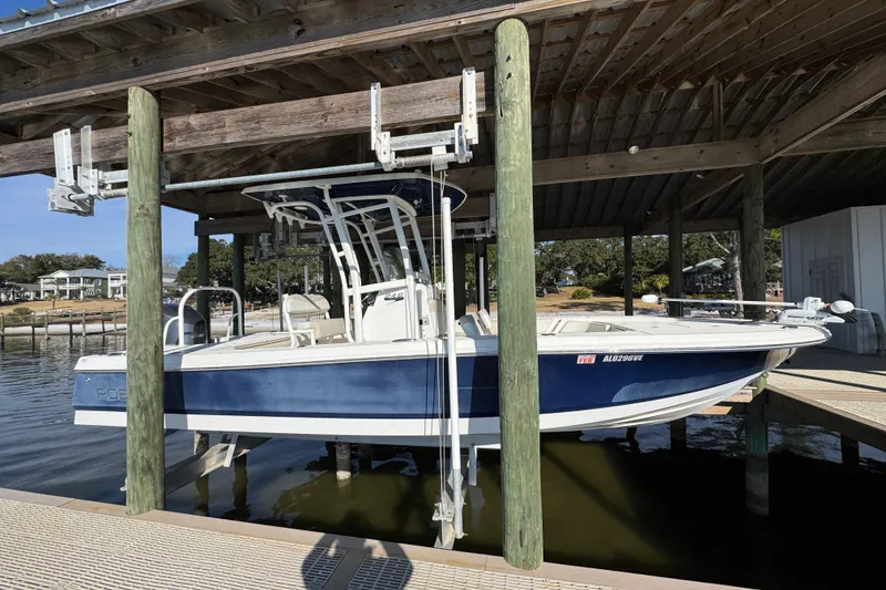 The Image of 2015 Robalo 246 Cayman boat docked under a wooden shelter. - 1