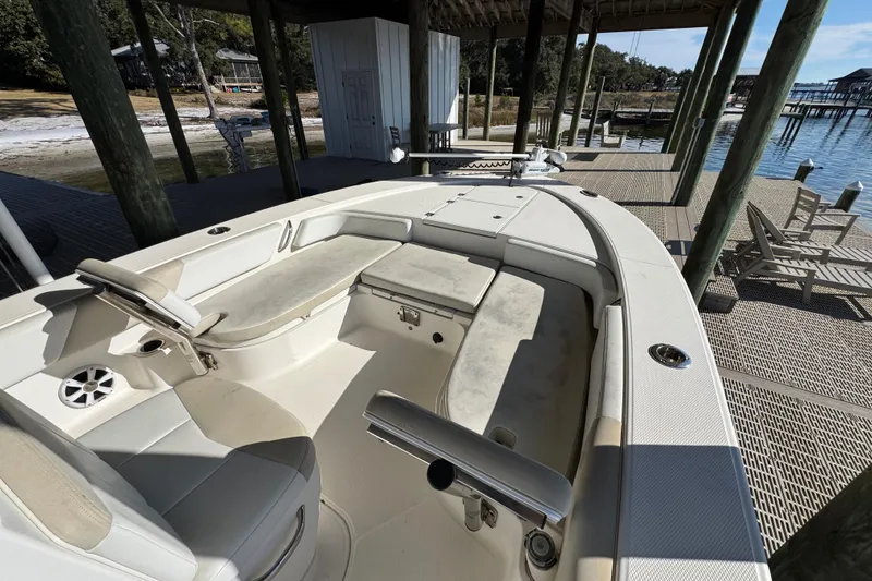 Slide: The Image of 2015 Robalo 246 Cayman boat interior at dock, featuring seating and steering area. - 10