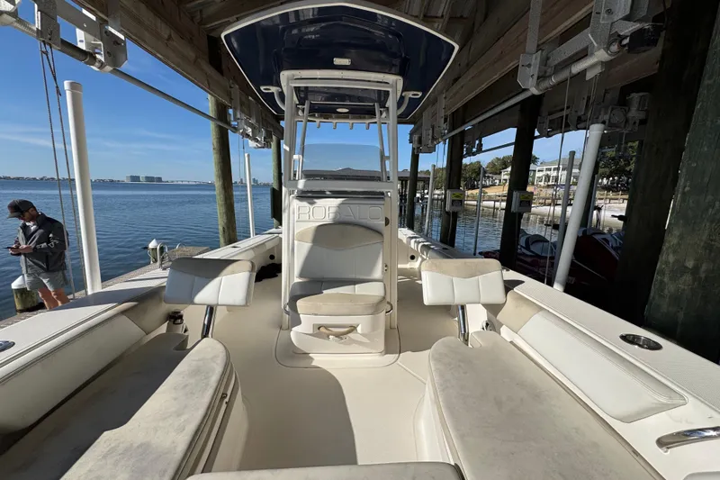 Slide: The Image of 2015 Robalo 246 Cayman boat docked, featuring spacious seating and console, with waterfront view. - 16