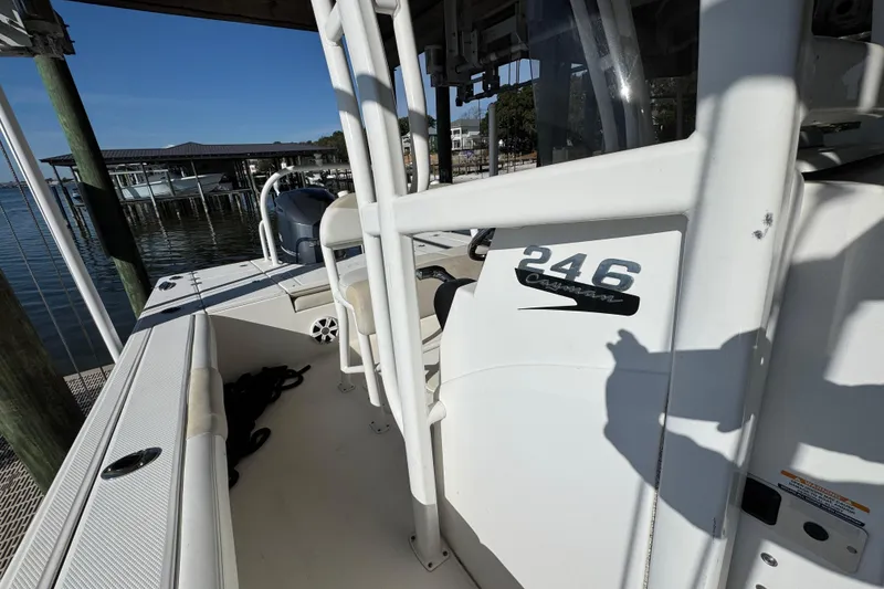 Slide: The Image of 2015 Robalo 246 Cayman boat docked at marina, showcasing interior and branding. - 18
