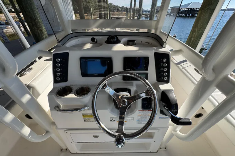 Slide: The Image of 2015 Robalo 246 Cayman boat dashboard with steering wheel and navigation controls. - 23