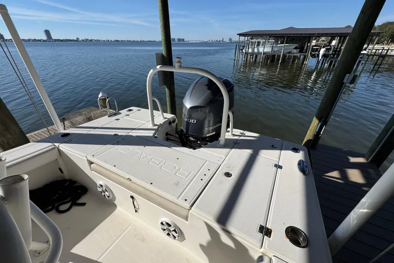 Slide: The Image of 2015 Robalo 246 Cayman boat docked by a serene waterfront. - 25