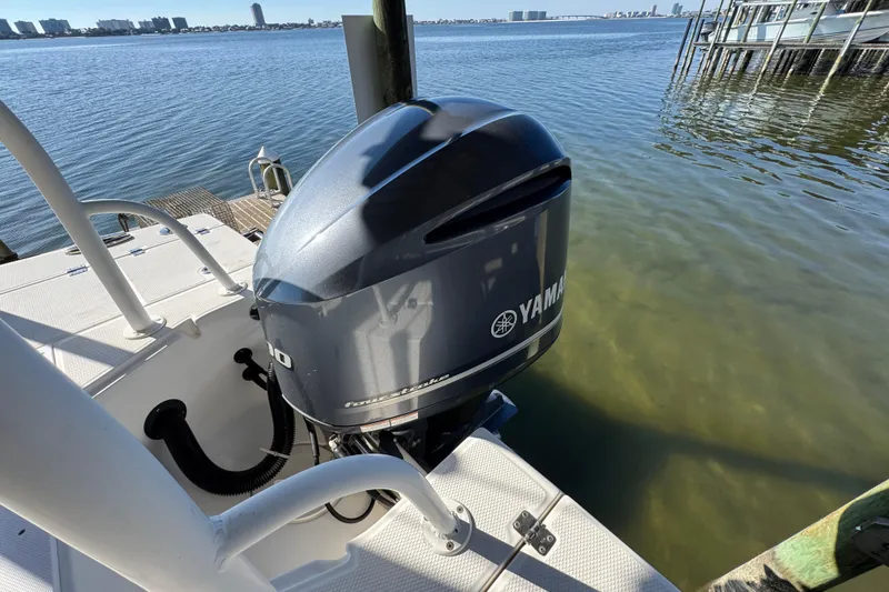 Slide: The Image of 2015 Robalo 246 Cayman with Yamaha outboard motor docked by the water. - 28