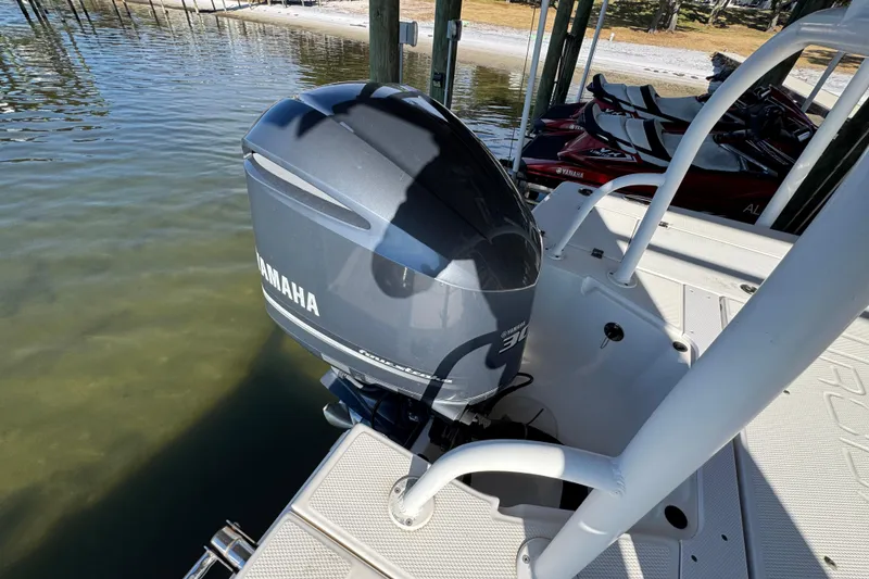Slide: The Image of 2015 Robalo 246 Cayman with Yamaha outboard motor docked by the water. - 29