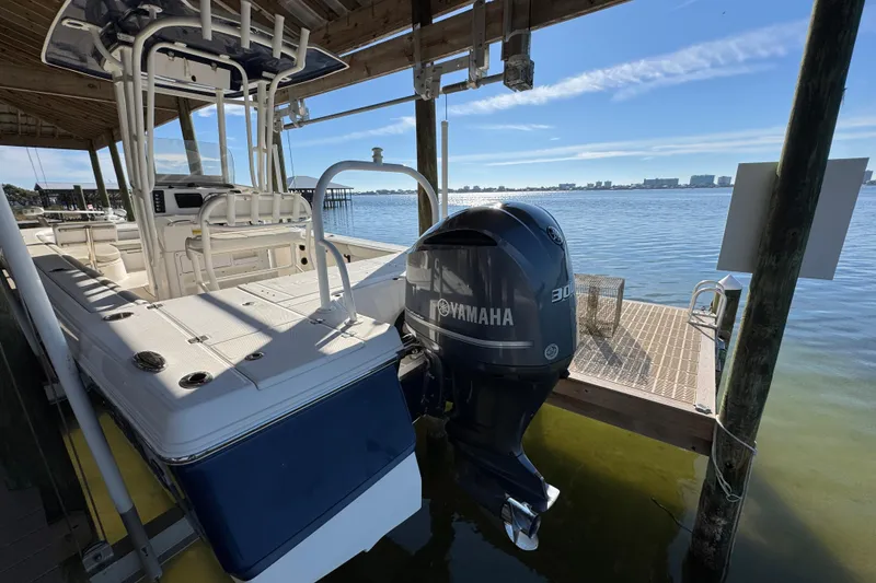 Slide: The Image of 2015 Robalo 246 Cayman boat with Yamaha engine docked by the water. - 8