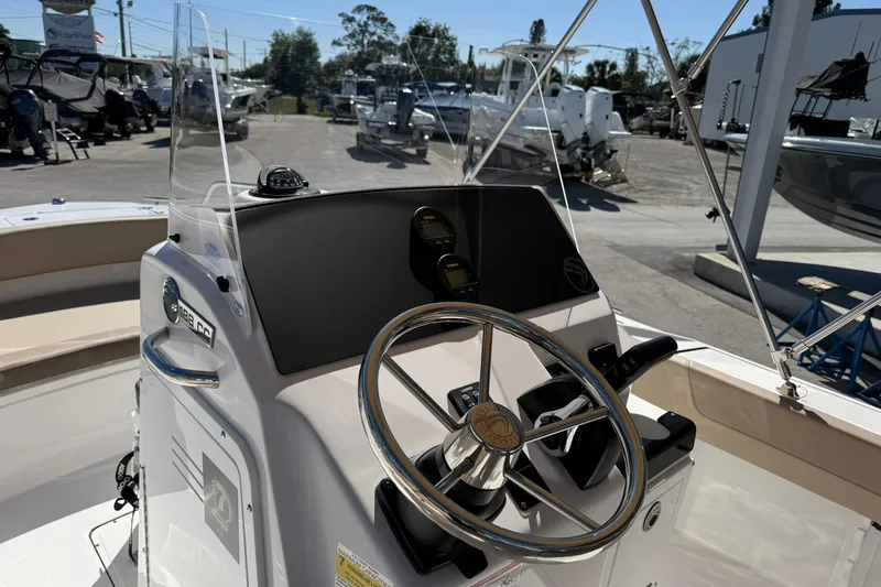 Slide: The Image of 2026 Edgewater 188CC boat console with steering wheel and controls in a marina setting. - 7