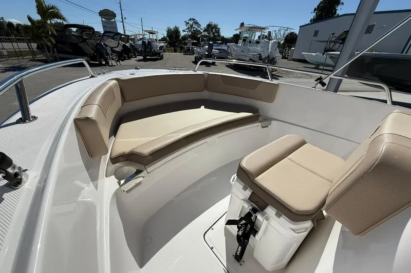 Slide: The Image of 2026 Edgewater 188CC boat interior with beige seating and storage, displayed outdoors. - 9
