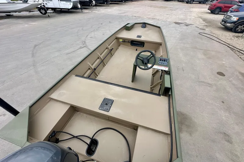 Slide: The Image of 2026 SeaArk 1652 Special boat, beige interior, steering console, parked on concrete surface. - 11