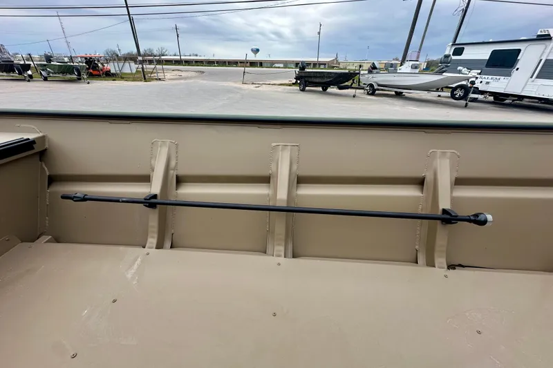 Slide: The Image of 2026 SeaArk 1652 Special boat interior with rod holder, parked outdoors. - 13